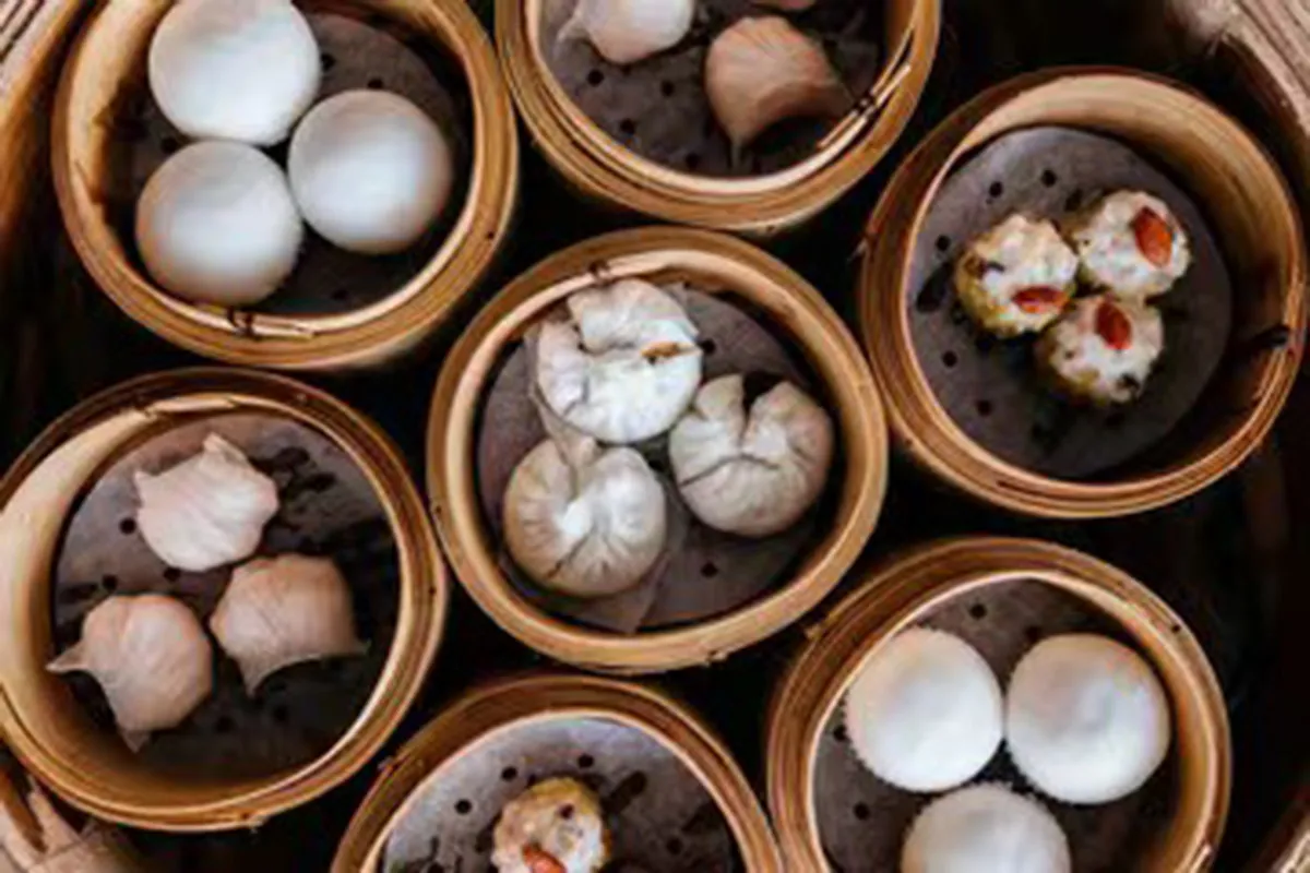 Top-down view of assorted dim sum varieties served in multiple bamboo steamers at One More Bite Dumpling, a Chinese Restaurant in Palm Desert